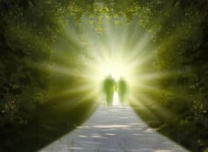 Two people are walking into the light of the paradise